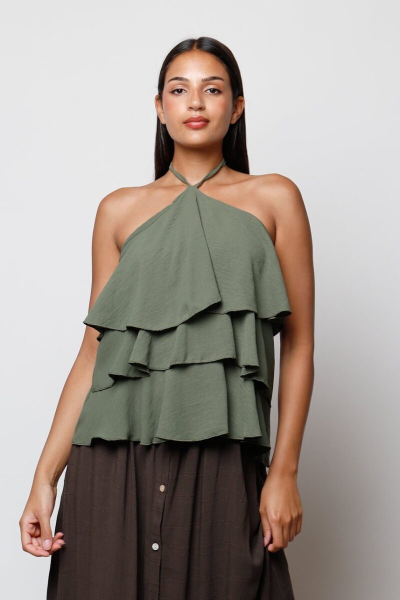 Mujer con top verde oliva de volantes y escote halter, estilo casual y femenino.
