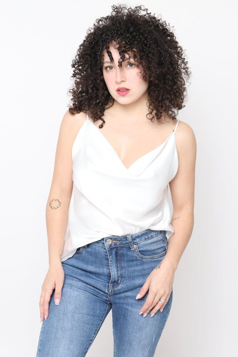 Mujer con top lencero blanco de tirantes finos y jeans, estilo casual