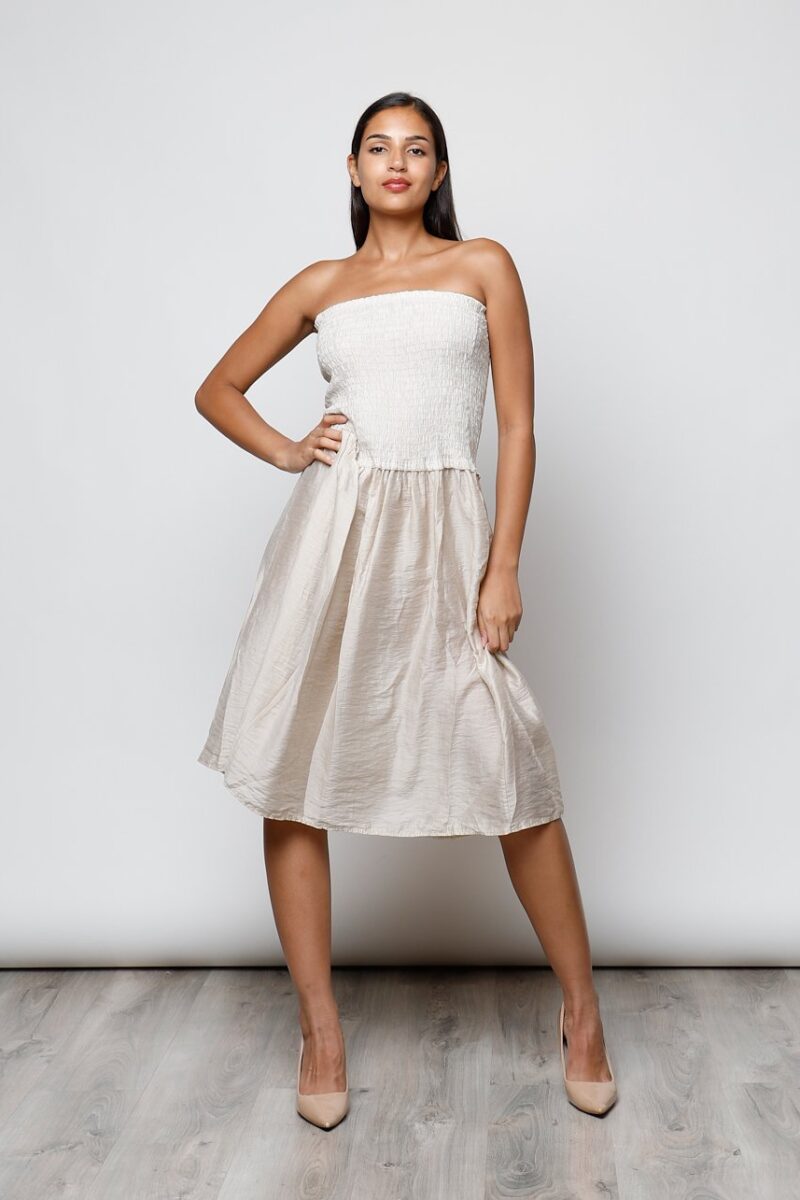Modelo con vestido palabra de honor color nude, falda midi fluida, estilo casual chic para verano
