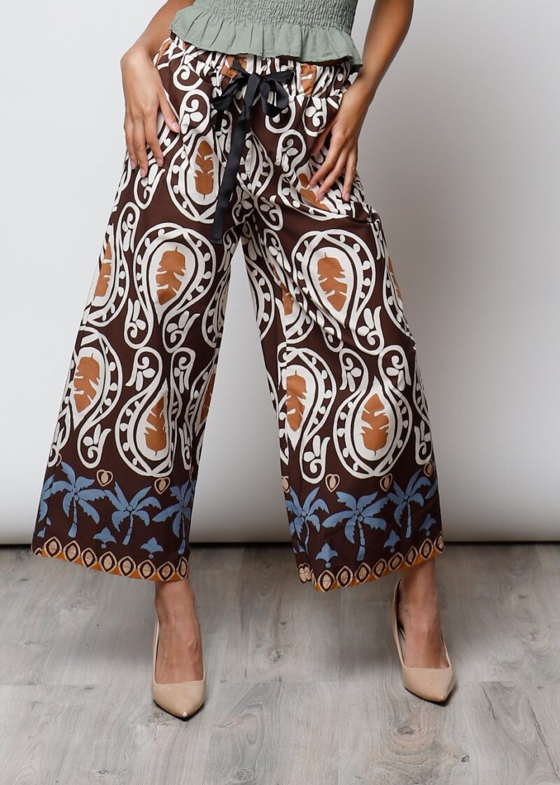 Pantalón Joana estilo palazzo con estampado tropical en tonos marrón, blanco y azul, modelo de perfil y de frente.