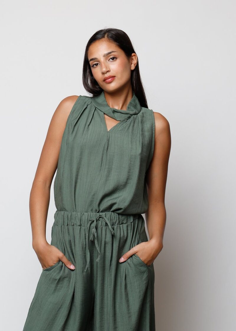 Mujer con top verde caqui sin mangas y escote cruzado estilo casual