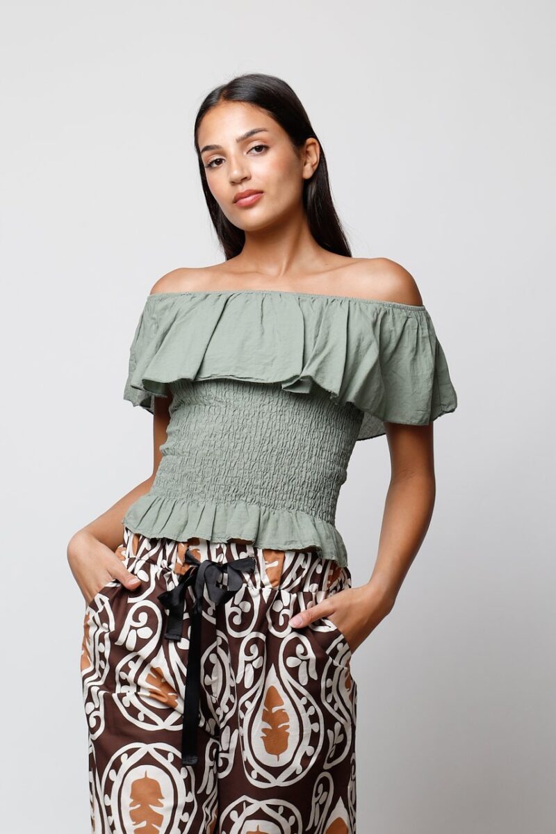Blusa Pauletta verde con volantes y tirantes off-shoulder, perfecta para un look casual y cómodo.