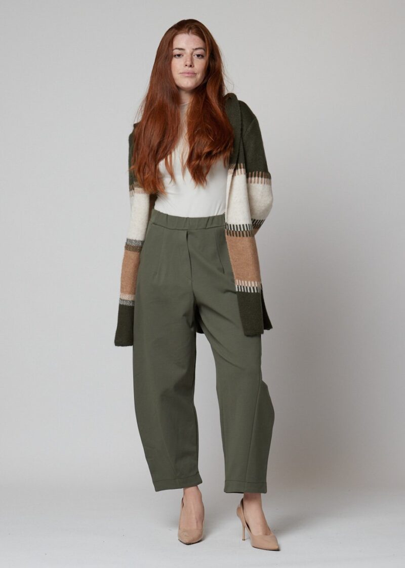 Mujer con pantalón verde oliva ancho y cárdigan de rayas beige y verdes