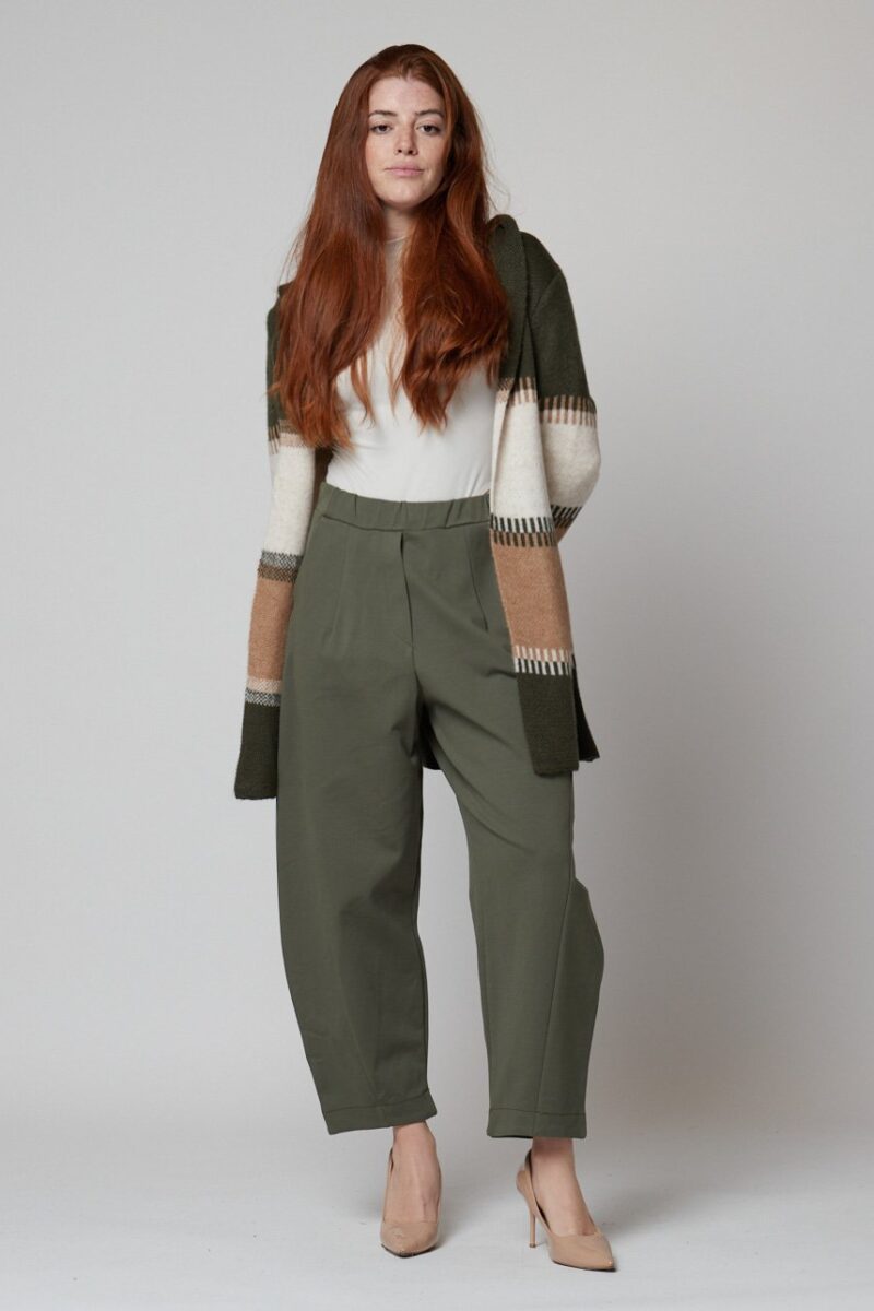 Mujer con pantalón verde oliva ancho y cárdigan de rayas beige y verdes