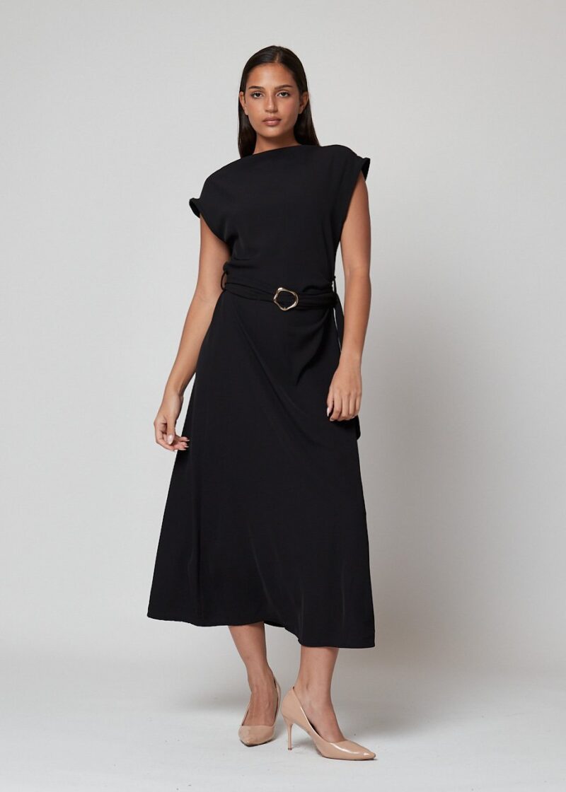 Mujer con vestido negro largo con cinturón dorado y tacones nude