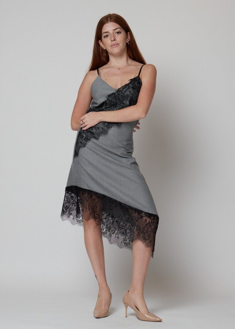 Mujer con vestido lencero gris midi con encaje negro y tacones nude