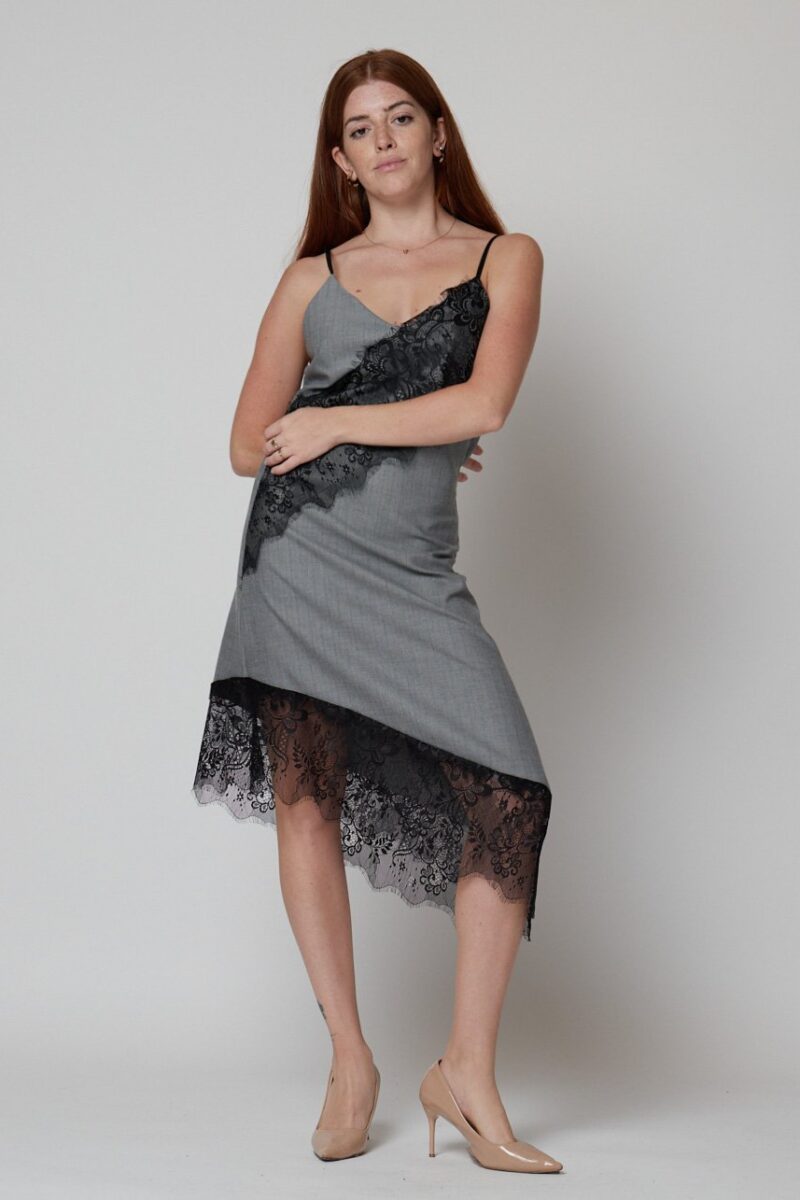 Mujer con vestido lencero gris midi con encaje negro y tacones nude