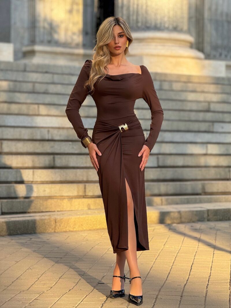 Mujer con vestido marrón elegante con escote barco y broche dorado de la colección eventos Maemuki