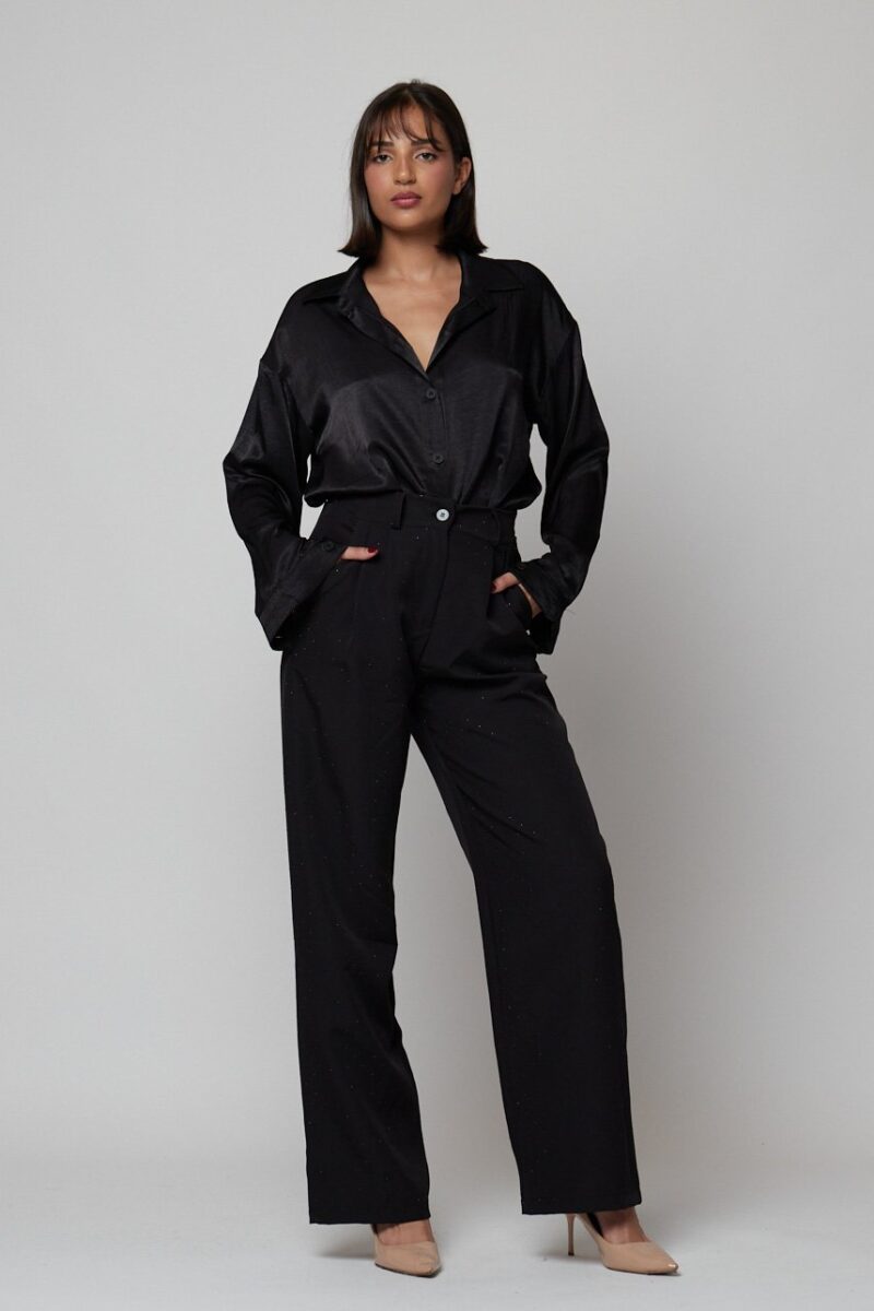 “Pantalón negro fluido con brillo sutil y cintura alta, combinado con camisa satinada negra – Maemuki Shop Tenerife”